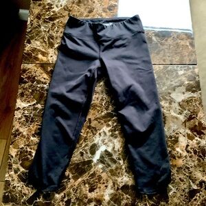 A black pair of leggings with holes at the bottom